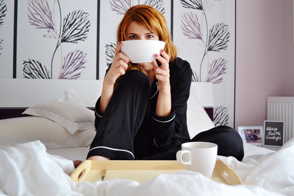 woman relaxing in bed with soup